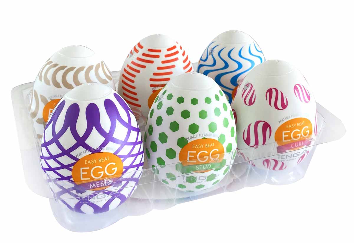 Сіра косметичка з прозорою вставкою, всередині фіолетовий вібратор, яйце, змазки